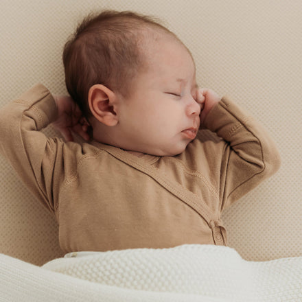 Baby in bed op Aerosleep hoeslaken almond