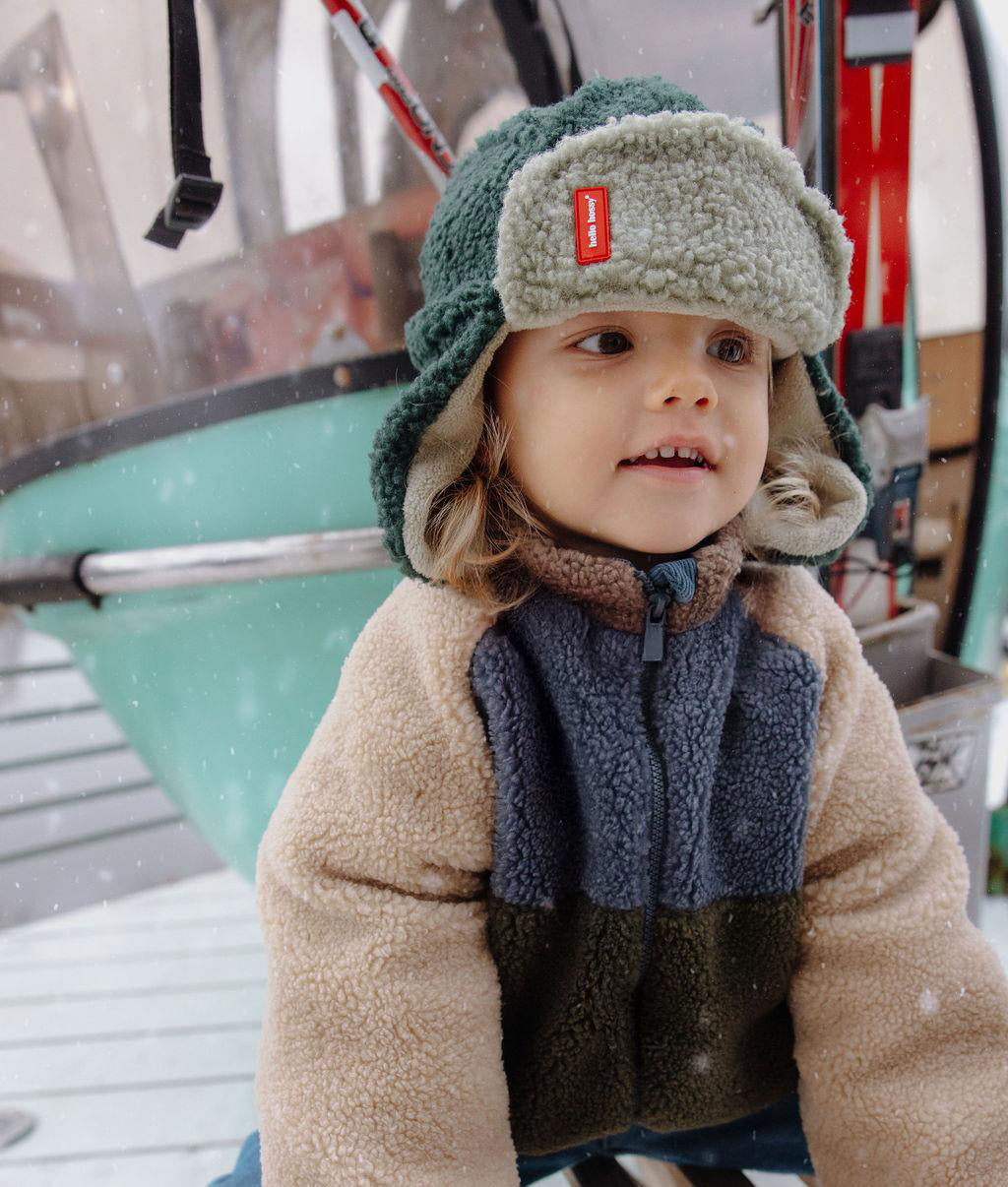 Hello Hossy muts met oorbescherming Cozy Neo, kind met muts bij de skilift