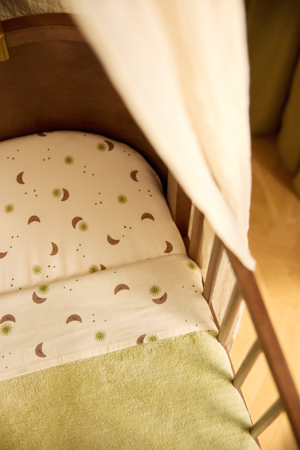 Sfeerbeeld van een babybedje met bedtextiel van Jollein in dromerige print