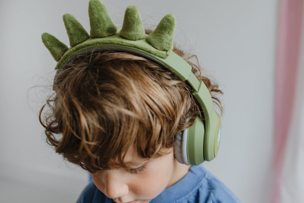 Kidywolf Kidyears Dino, close-up van een jongen met de koptelefoon van bovenaf