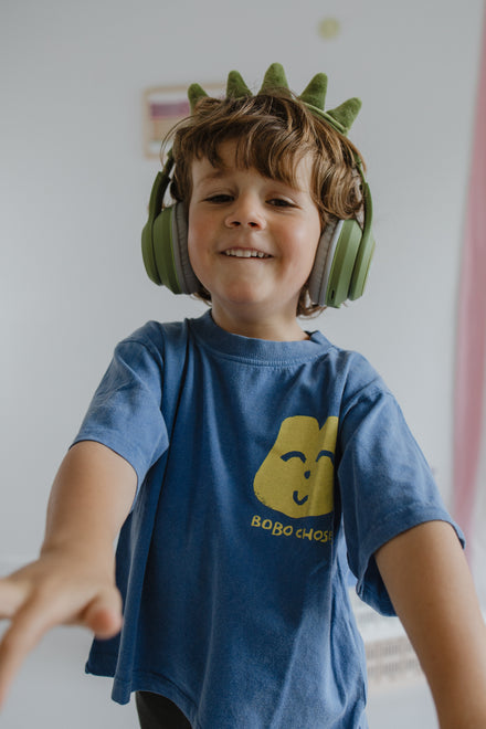 Kidywolf Kidyears Dino, lachende jongen draagt de koptelefoon
