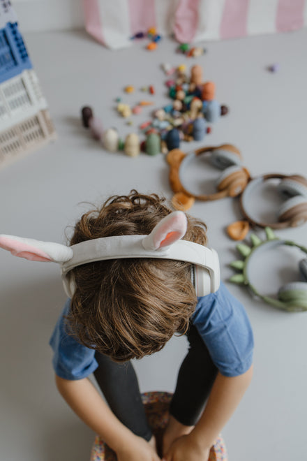 Kidywolf Kidyears Rabbit, kind speelt op de grond met de koptelefoon op
