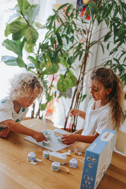 Kidywolf Kidyelec Starter Pack, twee kinderen experimenteren aan tafel tussen de planten