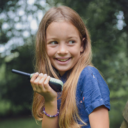 Kidywolf Kidytalk walkie talkie, lachend meisje met het toestel in het bos