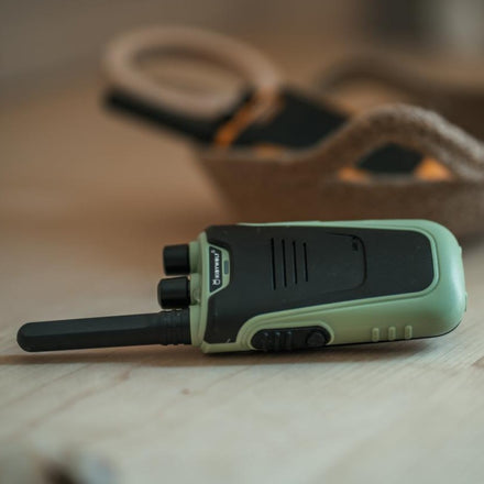 Kidywolf Kidytalk walkie talkie groen, liggend op tafel tussen knutselspullen