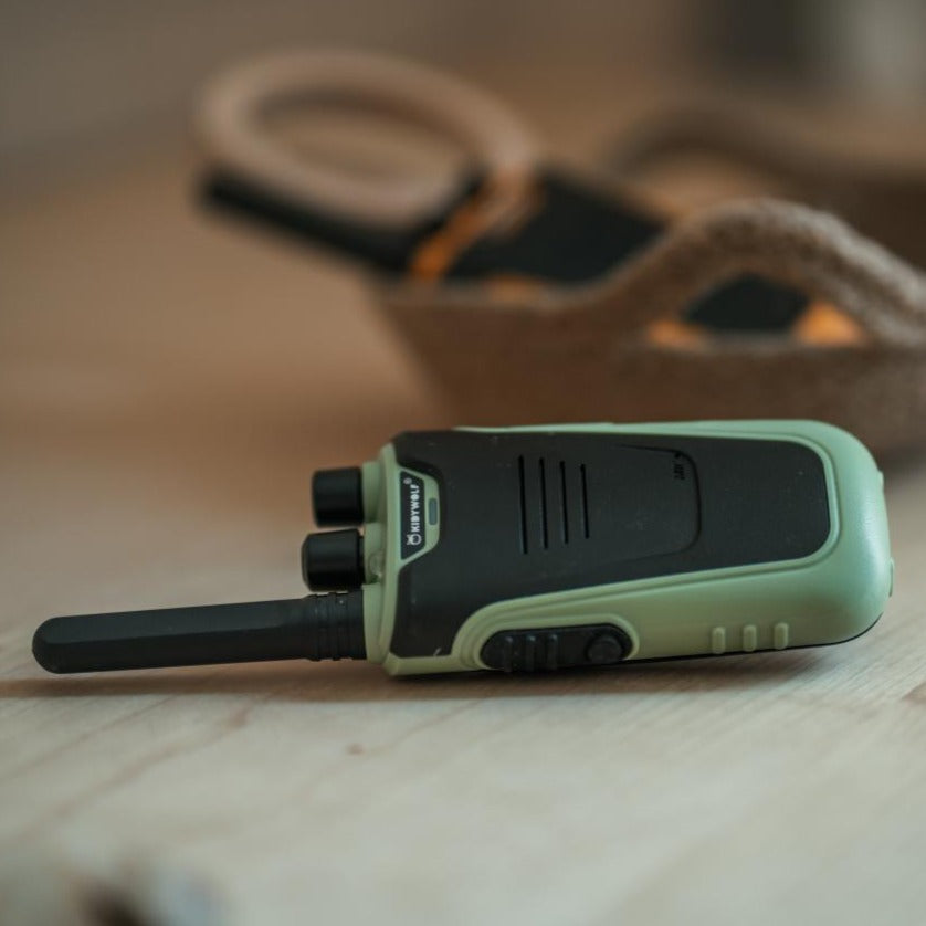 Kidywolf Kidytalk walkie talkie groen, liggend op tafel tussen knutselspullen