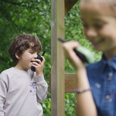 Kidywolf Kidytalk walkie talkie, jongen praat in het toestel in de tuin