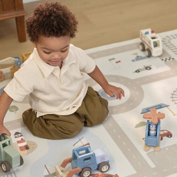 Kind speelt met houten voertuigen van Little Dutch op een speelkleed