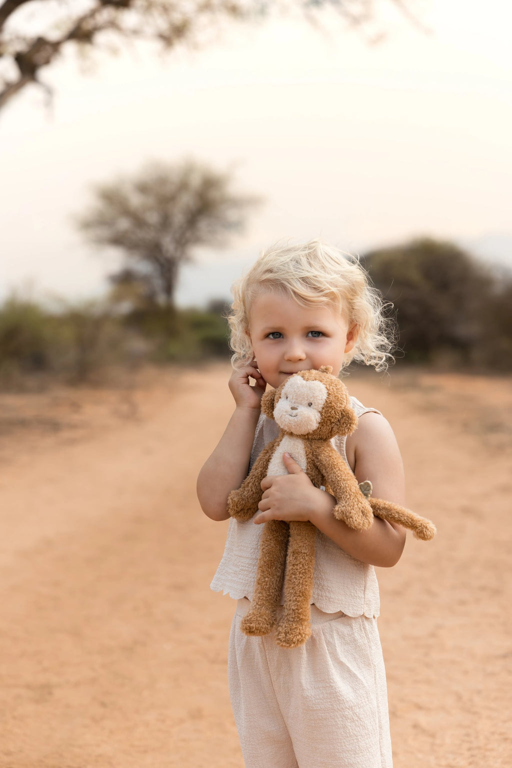 Kind knuffelt de Little Dutch knuffel aap Safari Friends buiten