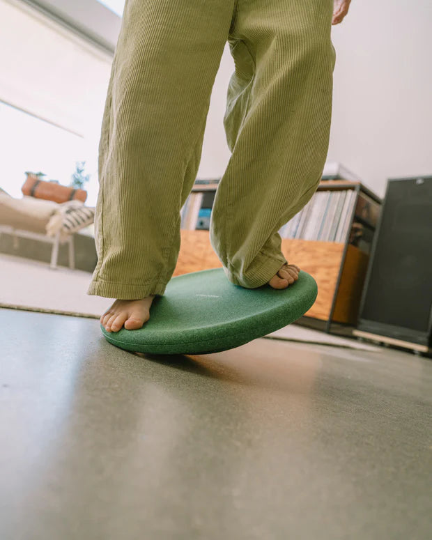 Stapelstein Balance Board Dark Green, close-up van kindervoeten die op het bord wiebelen