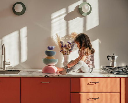 Stapelstein Inside Pastel Rainbow, kind speelt met de stenen in een zonnige keuken
