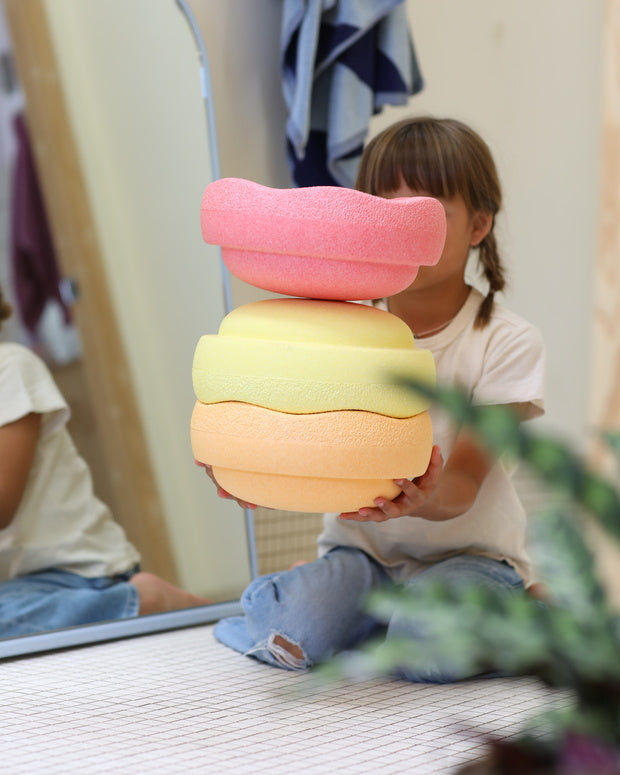 Stapelstein Original Rainbow Warm Pastel, kind bouwt een toren van pastelstenen
