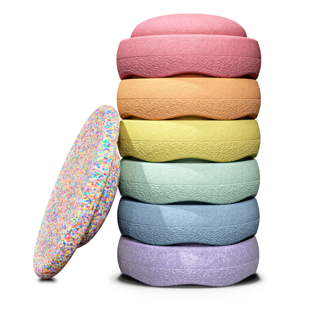 Stapelstein Special Rainbow Super Confetti Pastel, zes pastelstenen gestapeld naast het confetti balance board