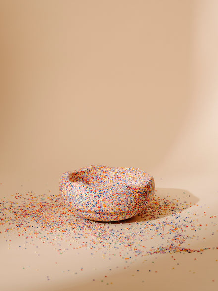 Stapelstein Steen Super Confetti, omgekeerd als schaaltje op een zandkleurige achtergrond