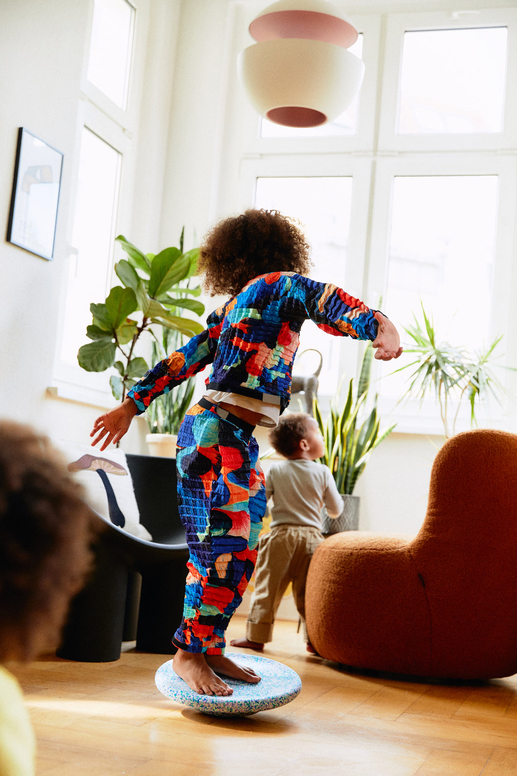 Stapelstein Balance Board Super Cool, kind balanceert staand op het bord in de woonkamer
