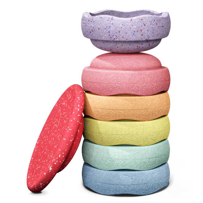 Stapelstein Winter Special Rainbow Set Pastel, zes pastelstenen gestapeld naast het rode board
