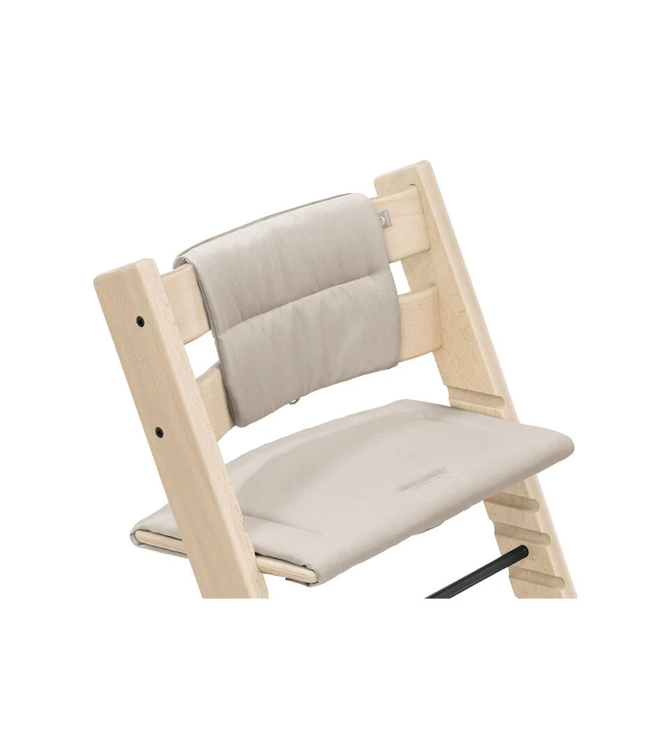 Stokke Tripp Trapp kussen Beige op een naturel beuken stoel