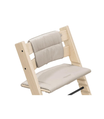 Stokke Tripp Trapp kussen Beige op een naturel beuken stoel