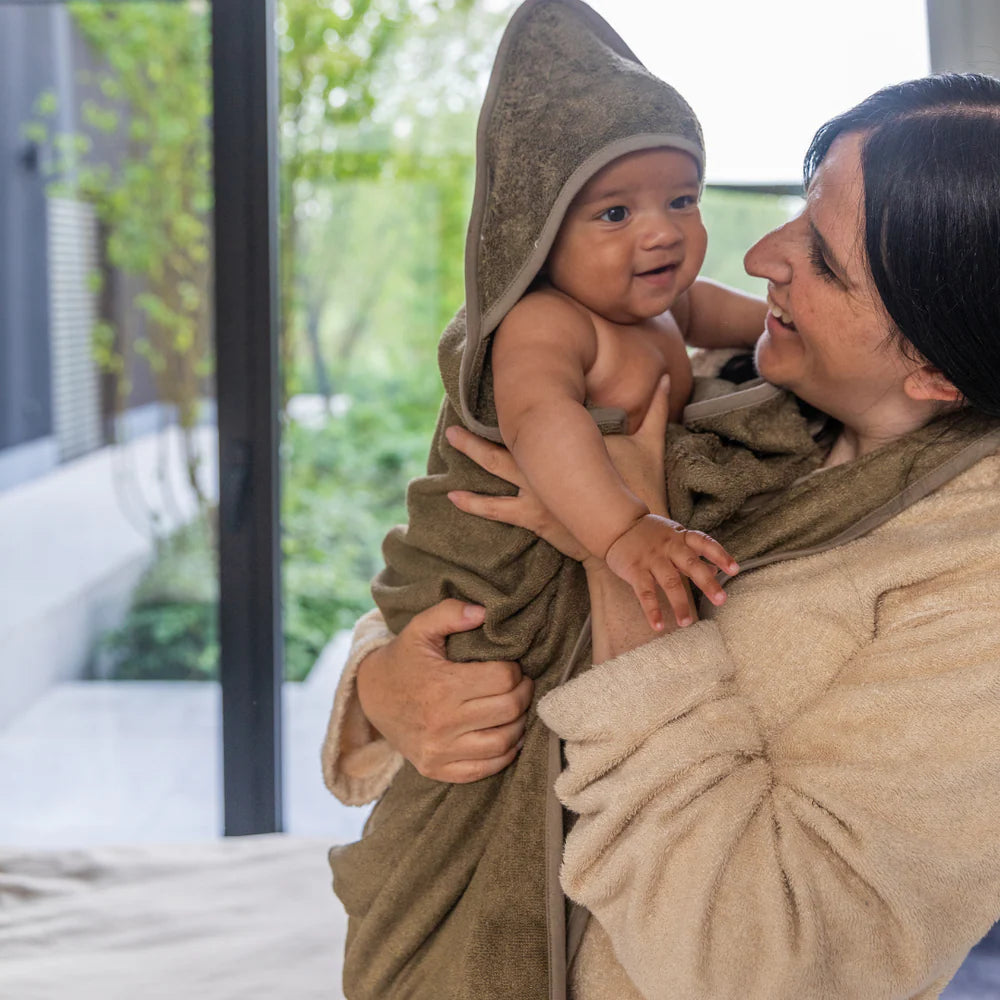 Timboo badcape ouder/baby bamboe Whisper Green, mama houdt haar baby in de handdoek met kap vast