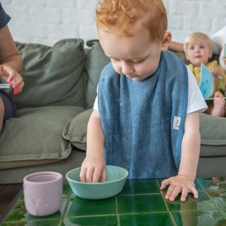 Timboo waterproof XL slab Marin, gedragen door een peuter aan tafel