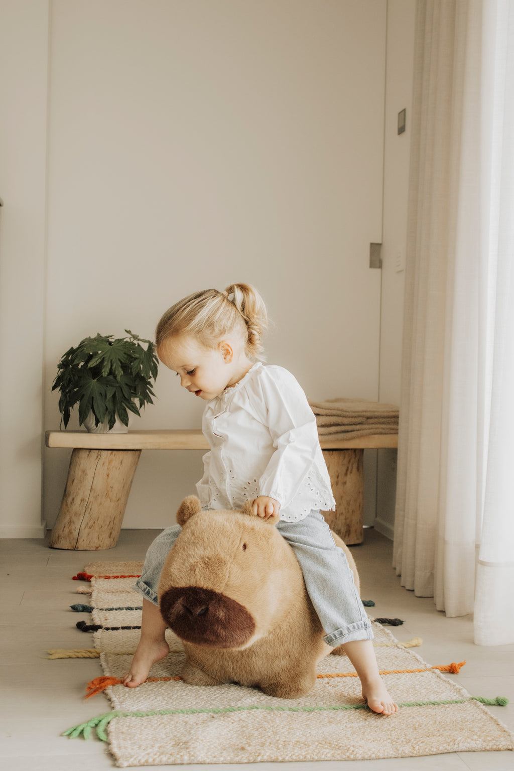 Wild & Soft Bouncy Capybara, meisje zit op het springdier en kijkt naar beneden
