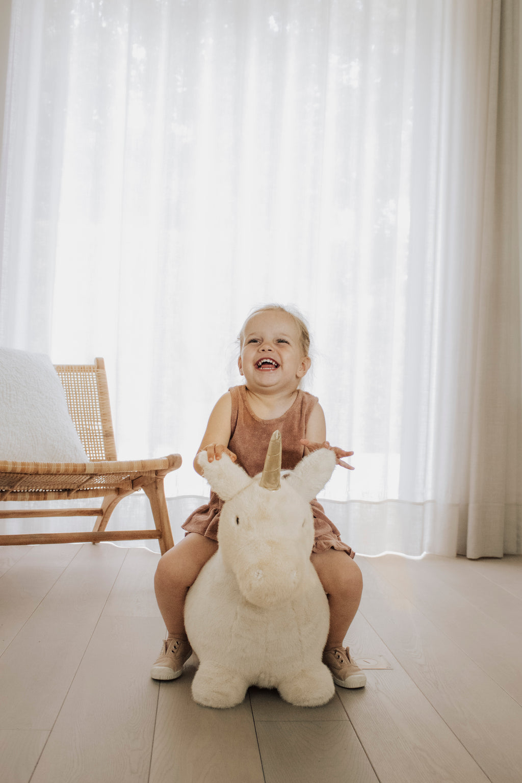 Wild & Soft Bouncy Eenhoorn, meisje op de eenhoorn in een lichte kamer, van ver
