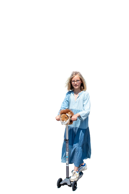 Wild & Soft Scooter Hoofd Leeuw, meisje in blauwe jurk rijdt op een step met het leeuwtje