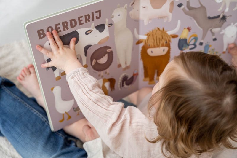 Little Dutch voorleesboek Mijn Eerste Dierenboek, kind bladert door het boek