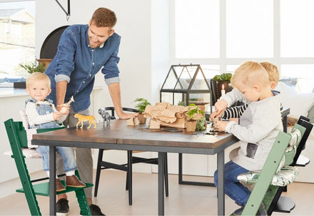Gezin aan tafel met Stokke Tripp Trapp stoelen in verschillende kleuren