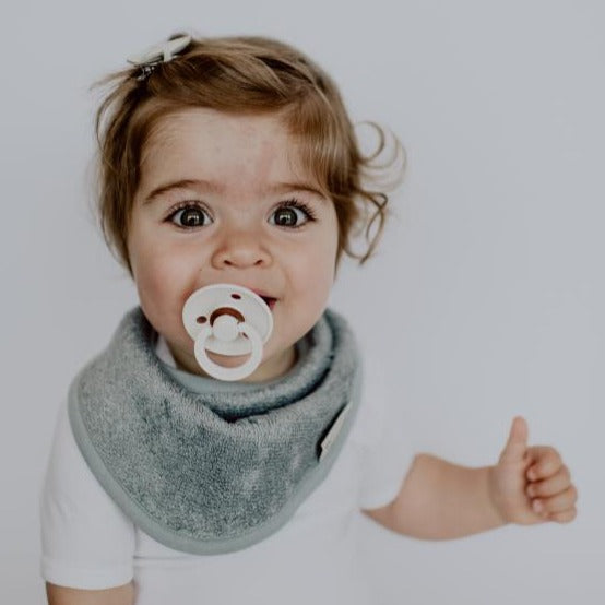 Timboo bandana slab dubbele laag bamboe Moon Blue gedragen door een baby met fopspeen